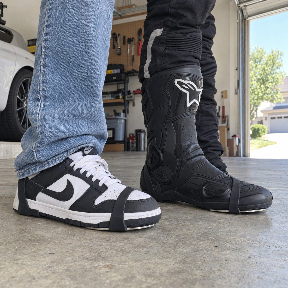 SparkRide strapped on a Nike Dunk Low sneaker and an Alpinestars riding boot, seen from the side, the rubber over the toe and around the heel